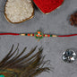 Green Tulsi Leaf Rakhi With Orange Enamel Flower And Beaded Thread